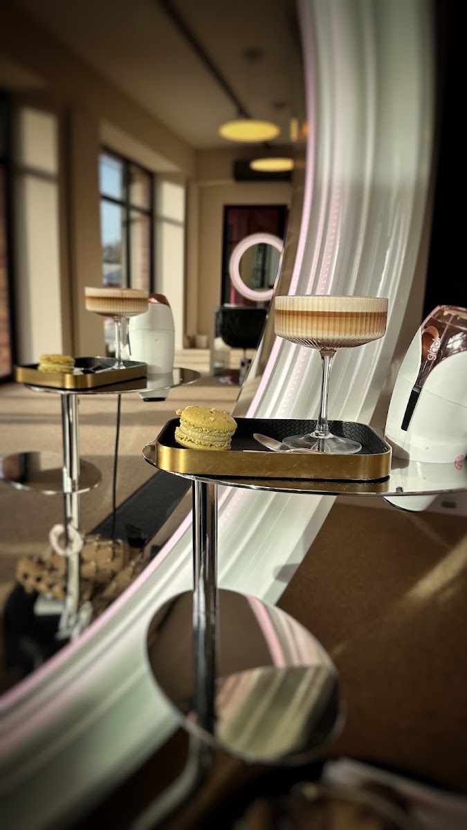 Ambiente im Salon De Luca Hair, Tablett mit Macaron vor beleuchtetem Rundspiegel